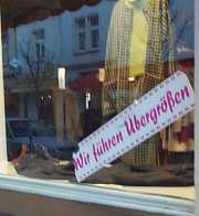 Schaufenster mit Schild: Wir führen Übergrössen